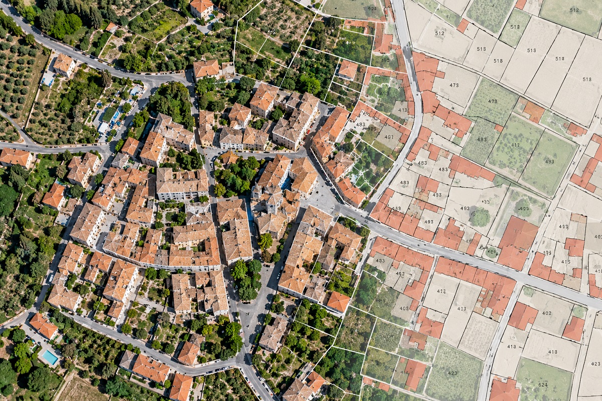 Aerial view of an Italian town with an illustrative overlay of cadastral parcels, building footprints and property boundaries.